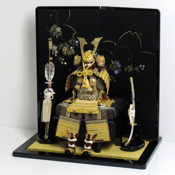 金色の小札を緋糸で威した品の良いコンパクト大鎧を桜の黒屏風で飾る五月人形