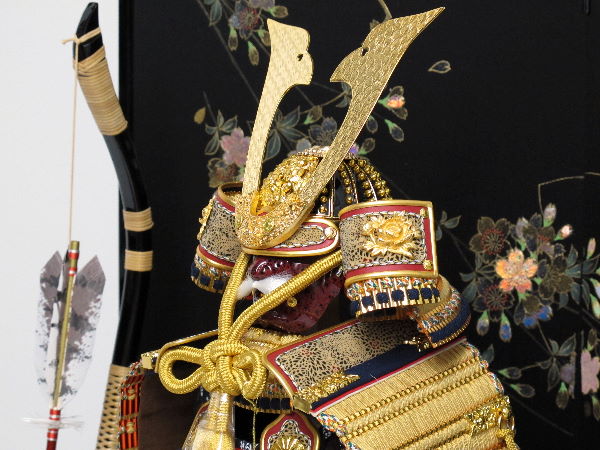 金色の小札を緋糸で威した品の良いコンパクト大鎧を桜の黒屏風で飾る五月人形