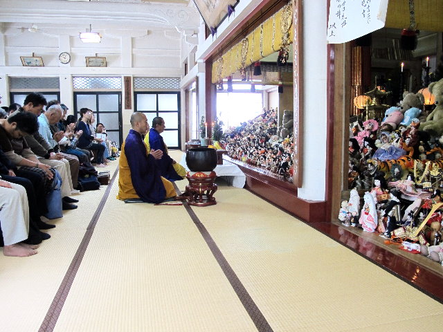 人形に対し読経する多聞院住職