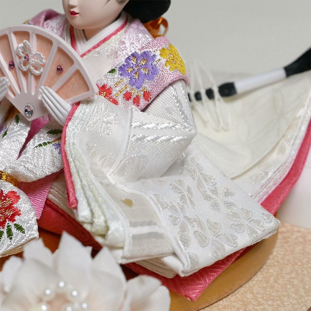 桜柄の白衣装に身を包んだ小芥子雛人形オールアクリルの木目ケース飾り