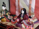 落ち着いた色合いの衣装を華やかに飾った伝統的工芸品の木目込み雛人形親王飾りです