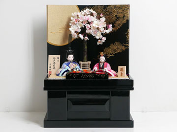 ピンク青波模様桜花柄縮緬衣装の木目込み人形黒地に月と松収納飾り