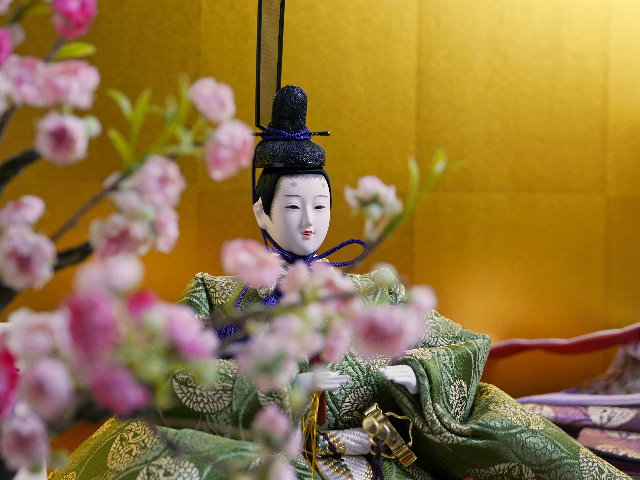 古典的な文様、丸の鶴を衣装に織り込んだ雛人形を金屏風と黒塗り台に並べる収納飾り