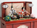 平安貴族の愛用した有職文様を織り込んだ伝統的な柄の衣装の人形をコンパクトな赤色の収納箱に並べた雛人形です。