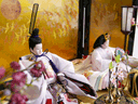 淡い薄ピンクの雛人形を鶴の金屏風と黒塗り台に並べる収納飾り