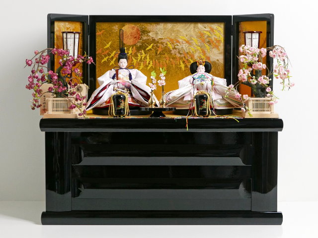 淡い薄ピンクの雛人形を鶴の金屏風と黒塗り台に並べる収納飾りが安い 雛人形収納飾り～広島市の人形問屋十二段屋