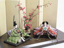 古典的な文様、丸の鶴を衣装に織り込んだ雛人形の紅梅創作飾り