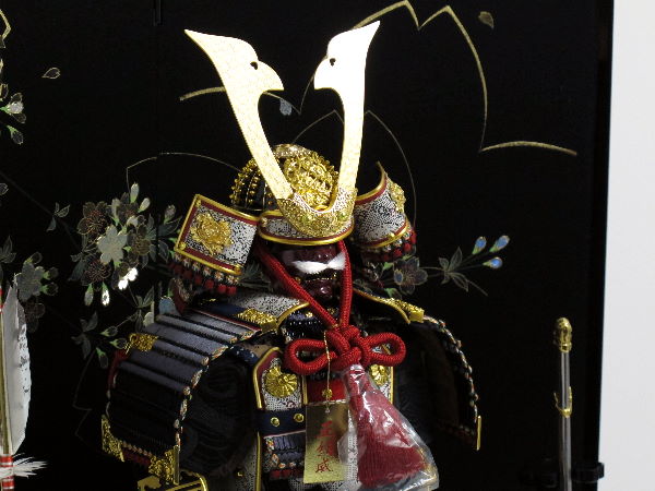 黒い小札を黒糸で威した渋めのコンパクト大鎧を桜の黒屏風で飾る五月人形