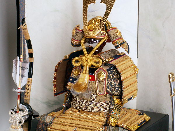 金色の小札を緋糸で威した豪華で品の良いコンパクト7号大鎧をすっきりとした二曲屏風で飾る五月人形
